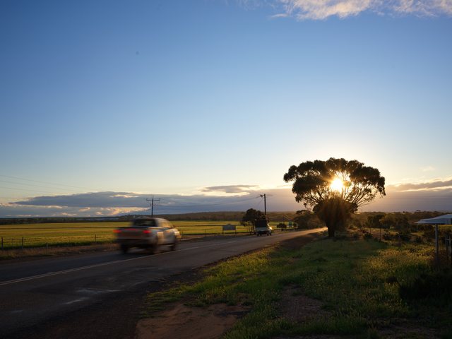夕阳、田野与路上的车。