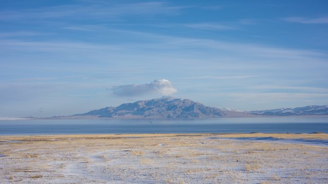 冰雪湖岸与远方孤峰。