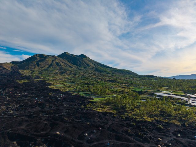 绿色山坡与低处村落或道路航拍。