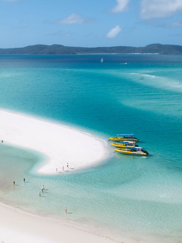 白沙、透明浅水与岸旁黄色小船。